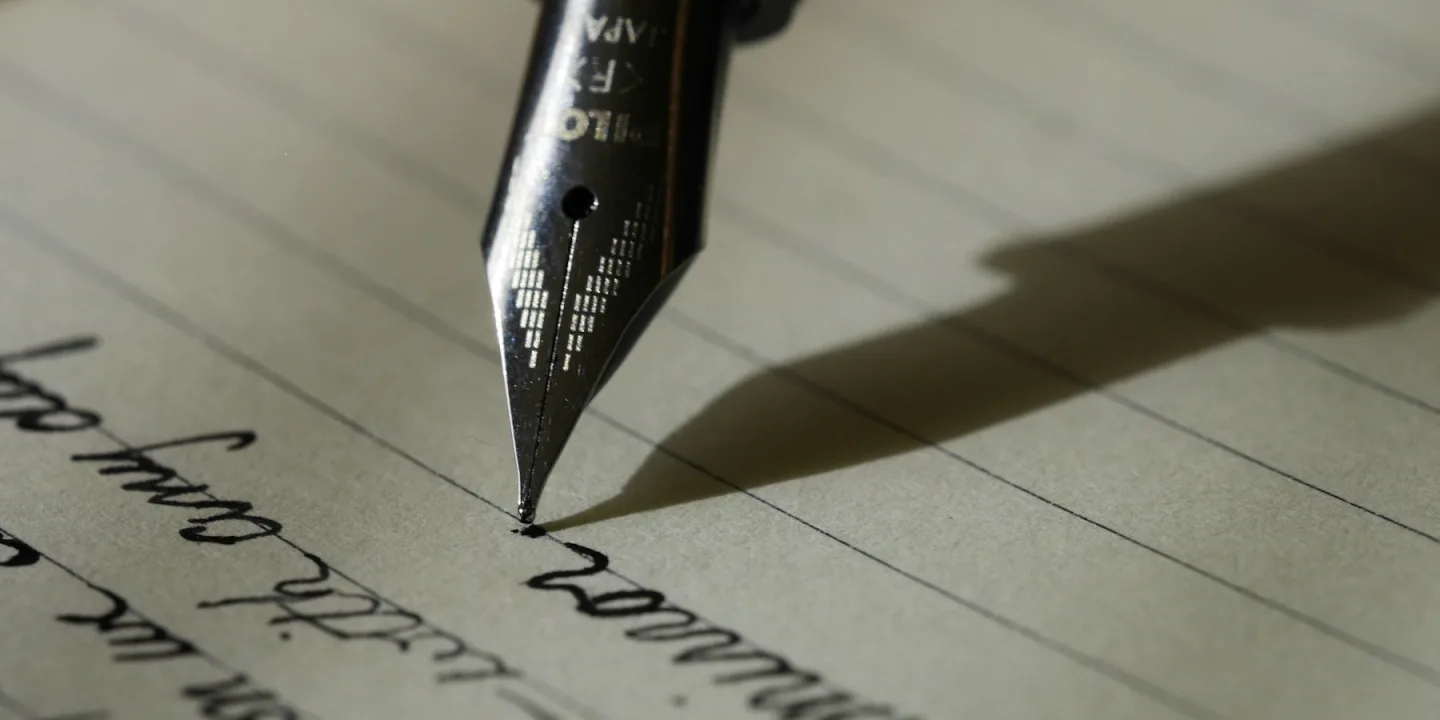 A fountain pen resting on an open notebook